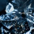 Close-up image of sparkling diamonds on a dark surface. Close-up image of sparkling diamonds on a dark surface.