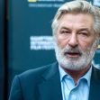 Alec Baldwin speaking at an event, with a focused expression amid a backdrop featuring a logo. Alec Baldwin speaking at an event, with a focused expression amid a backdrop featuring a logo.
