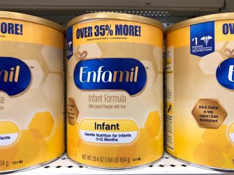 Cans of Enfamil infant formula on a store shelf.