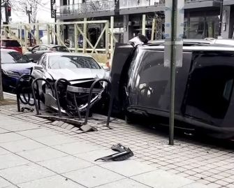 Scene of a car crash involving a flipped vehicle and damaged cars on a city street.