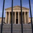 U.S. Supreme Court building viewed through a fence. U.S. Supreme Court building viewed through a fence.