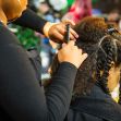 A person receiving hairstyling in a salon, focusing on natural and braided hairstyles. A person receiving hairstyling in a salon, focusing on natural and braided hairstyles.