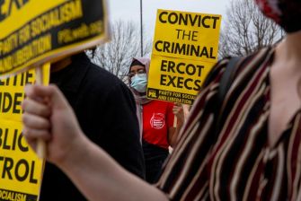 Protesters holding signs demanding accountability from ERCOT executives during a demonstration related to the 2021 Winter Storm losses in Texas.