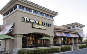 Exterior view of a Panera Bread restaurant featuring the sign and a drive-thru lane.