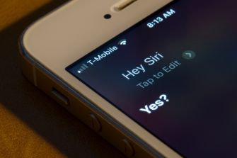 Image of a smartphone screen displaying the Siri interface with the prompt "Hey Siri" visible.