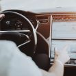 A person interacting with the touchscreen interface of a Tesla vehicle, showcasing autonomous driving features. A person interacting with the touchscreen interface of a Tesla vehicle, showcasing autonomous driving features.