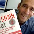 An osteopathic physician holding a book titled "The No-Grain Diet." An osteopathic physician holding a book titled "The No-Grain Diet."
