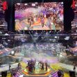 A large esports event with spectators, a stage featuring gaming setups, and a celebratory atmosphere. A large esports event with spectators, a stage featuring gaming setups, and a celebratory atmosphere.