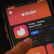 A person interacting with the Tinder dating app on a mobile phone. A person interacting with the Tinder dating app on a mobile phone.