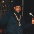 DJ Jam Master Jay performing on stage, wearing a large chain and a black hat. DJ Jam Master Jay performing on stage, wearing a large chain and a black hat.