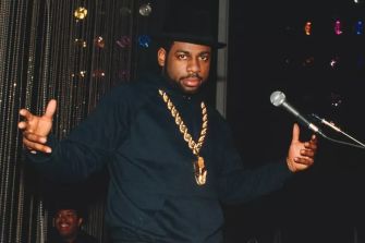DJ Jam Master Jay performing on stage, wearing a large chain and a black hat.