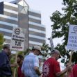 Workers participating in a UAW strike, holding signs calling for better labor practices and working conditions. Workers participating in a UAW strike, holding signs calling for better labor practices and working conditions.