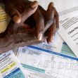 Hands clasped over medical bills with a "PAST DUE" notice prominently displayed. Hands clasped over medical bills with a "PAST DUE" notice prominently displayed.