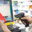 A person using a barcode scanner to check medication prices at a pharmacy. A person using a barcode scanner to check medication prices at a pharmacy.