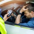 An officer administering a breathalyzer test to a distressed driver in a vehicle. An officer administering a breathalyzer test to a distressed driver in a vehicle.