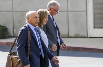 Three individuals walking together outside a building, dressed in formal attire, in relation to a legal case involving sexual abuse allegations.
