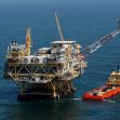 Oil drilling platform in the ocean with a supply boat alongside. Oil drilling platform in the ocean with a supply boat alongside.
