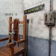 Electric chair in a prison setting, labeled "BLOCK D" and "HIGH VOLTAGE." Electric chair in a prison setting, labeled "BLOCK D" and "HIGH VOLTAGE."