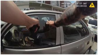 Bodycam footage showing an officer aiming a gun during a traffic stop.