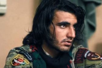 An Afghan man in military attire, appearing serious and contemplative.