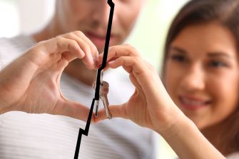 Image of a couple making a heart shape with their hands, holding keys in the center, symbolizing the emotional divide in a relationship.
