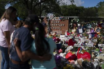 Vigil at Robb Elementary School memorial with flowers and tributes honoring the victims of the Uvalde school shooting.