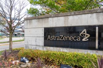 A sign displaying the AstraZeneca logo at their corporate headquarters, surrounded by landscaping.