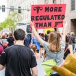 Protesters holding signs advocating for abortion rights, with one sign reading "More Regulated Than Guns." Protesters holding signs advocating for abortion rights, with one sign reading "More Regulated Than Guns."