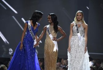 Contestants in evening gowns at a beauty pageant event.