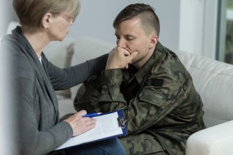 A U.S. Army veteran receives support during a counseling session, highlighting the impact of PTSD on his life.