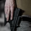 A close-up image of a person holding a handgun in a holster, resting on their hip. The background is blurred, focusing on the firearm. A close-up image of a person holding a handgun in a holster, resting on their hip. The background is blurred, focusing on the firearm.