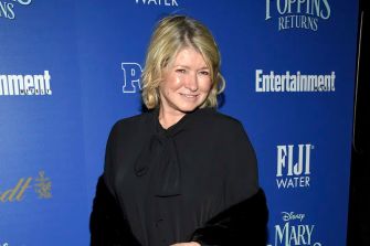 Martha Stewart at an event, wearing a black outfit and smiling.