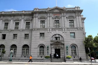Exterior view of the Ninth Circuit Court of Appeals building in San Francisco, California, with people walking in front.