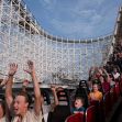 A wooden roller coaster in operation with riders experiencing excitement and thrill. A wooden roller coaster in operation with riders experiencing excitement and thrill.
