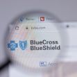 Logo of Blue Cross Blue Shield displayed on a website, viewed through a magnifying glass. Logo of Blue Cross Blue Shield displayed on a website, viewed through a magnifying glass.