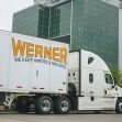 A Werner truck parked in front of a modern building. A Werner truck parked in front of a modern building.