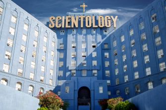 Exterior view of a large blue building with a sign reading "Scientology" at the top.