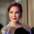 Priscilla Presley at a public event, wearing a sparkling outfit and looking seriously into the camera. Priscilla Presley at a public event, wearing a sparkling outfit and looking seriously into the camera.