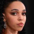 Close-up portrait of musician FKA Twigs, featuring dramatic makeup and ornate earrings. Close-up portrait of musician FKA Twigs, featuring dramatic makeup and ornate earrings.