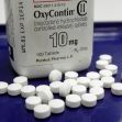 A bottle of OxyContin tablets with some pills scattered around it. A bottle of OxyContin tablets with some pills scattered around it.