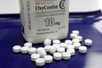 A bottle of OxyContin tablets with some pills scattered around it.