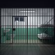 Image of a jail cell interior with two beds, visible bars, and minimal furnishings, highlighting the conditions faced by correctional officers. Image of a jail cell interior with two beds, visible bars, and minimal furnishings, highlighting the conditions faced by correctional officers.