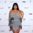Lizzo attending an event in a stylish gray dress with ruffles. Lizzo attending an event in a stylish gray dress with ruffles.
