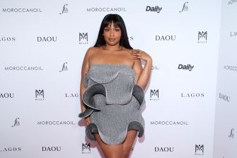Lizzo attending an event in a stylish gray dress with ruffles.