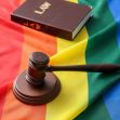 A gavel and a law book resting on a rainbow flag, symbolizing LGBTQ+ rights and legal issues. A gavel and a law book resting on a rainbow flag, symbolizing LGBTQ+ rights and legal issues.