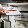 A person depositing a mail-in ballot into a drop box designated for official ballots. A person depositing a mail-in ballot into a drop box designated for official ballots.