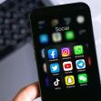 A smartphone displaying various social media app icons, including Facebook, Instagram, WhatsApp, and others, arranged in a folder labeled "Social." A smartphone displaying various social media app icons, including Facebook, Instagram, WhatsApp, and others, arranged in a folder labeled "Social."
