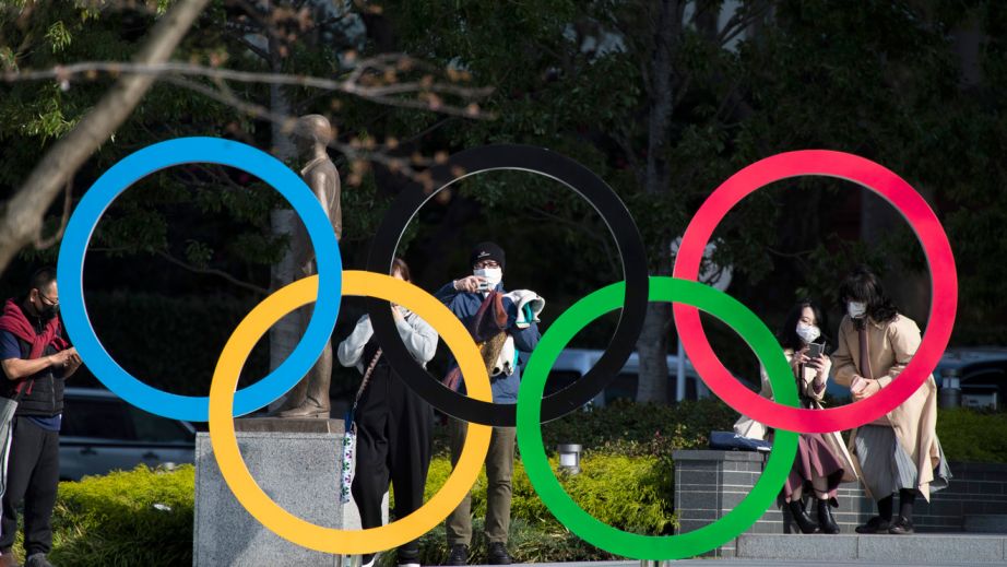 In this March 19, 2021, file photo, people take pictures of the Olympic rings installed by the Japan Olympic Museum in Tokyo. The vaccine rollout in Japan has been very slow with less than 1% vaccinated. This of course is spilling over to concerns about the postponed Tokyo Olympics that open in just over three months.(AP Photo/Hiro Komae, File)
