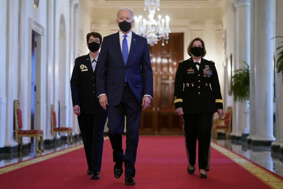 President Joe Biden walks with U.S. Air Force Gen. Jacqueline Van Ovost, left, and U.S. Army Lt. Gen. Laura Richardson before speaking at an event to mark International Women's Day, Monday, March 8, 2021, in the East Room of the White House in Washington. (AP Photo/Patrick Semansky)