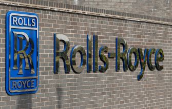 Signage of Rolls-Royce displayed on a brick wall.